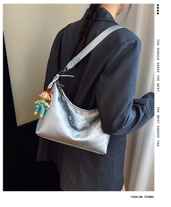 Detailed view of silver hobo bag with metallic chain strap and cute cartoon pendant