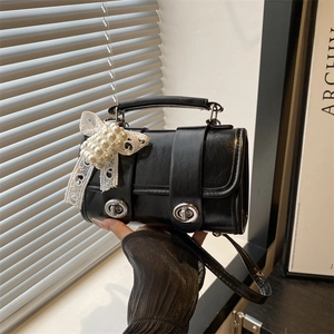 Sac à main chic en cuir noir avec verrous argentés, nœud en dentelle et perles