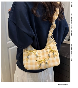 Side view of yellow plaid shoulder bag with ribbon bows and silver beads decoration