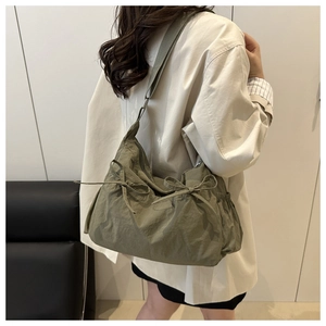 Dettaglio della borsa a spalla in nylon verde militare con coulisse decorative e tracolla