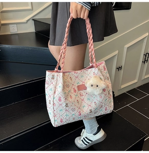 Détail du sac cabas floral à texture gaufrée, poignée tissée rose et charm étoile doux