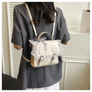 Detail of a beige Lolita backpack with lace trim and pink bow, worn by a model