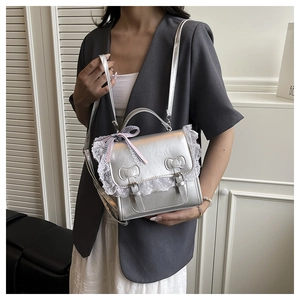 Detail of silver metallic purse with white lace edges and bow-shaped metal clasps
