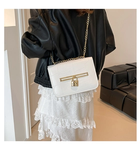 Detailed close-up of white crocodile pattern PU leather bag with golden chain strap