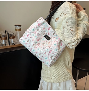 Détail d'un cabas floral avec tissu texturé et poignée tressée dans un café chic