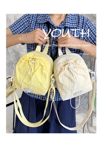 Detail of mini drawstring nylon crossbody bags in bright yellow and cream white