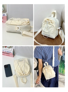 Detail view of cream drawstring crossbody bag with fashion logo and zipper textures