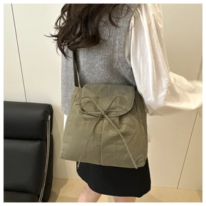 Dettaglio del grande fiocco sulla borsa a tracolla casual in nylon verde oliva da donna