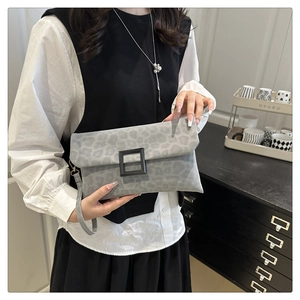 Detail of grey leopard print faux suede clutch bag with black square buckle and wristlet