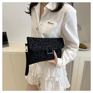Detail of black leopard print clutch bag with matte square clasp and velvet texture