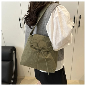 Dettaglio della borsa hobo verde oliva con fiocco e morbida trama in nylon pieghettato
