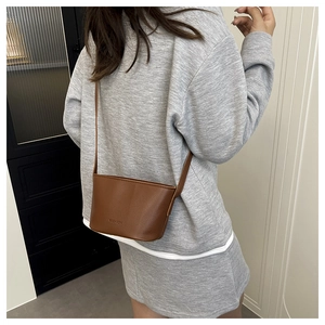 Detail of dark brown litchi pattern bucket bag with FASHION embossing for women