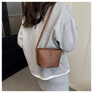 Brown litchi pattern bucket bag shown on model to demonstrate size and stylish fit
