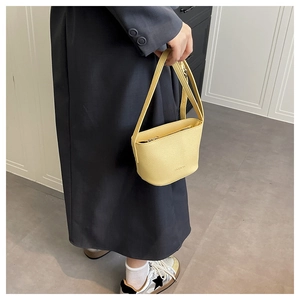 Detail of yellow lychee texture bucket bag with metal zipper and fashion embossing
