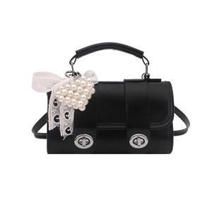 Bolso bandolera de cuero negro con hebillas metálicas y colgante de perla de corazón