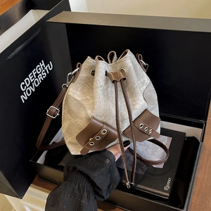 Minimalist drawstring bucket bag in canvas and brown leather, stylish retro crossbody style