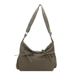 Olive green nylon crossbody bag with drawstring bow details and adjustable wide strap