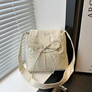 Borsa a tracolla beige minimalista con fiocco e tracolla larga in luce naturale