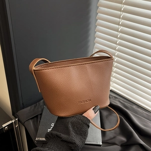 Chic brown lychee pattern bucket bag with a thin shoulder strap and FASHION logo