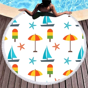 Toalla de playa redonda gruesa con motivos náuticos y borlas junto a una piscina