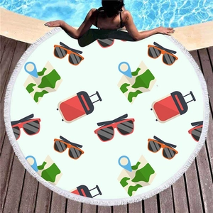 Round beach towel with cartoon travel icons and white fringe on pool deck background