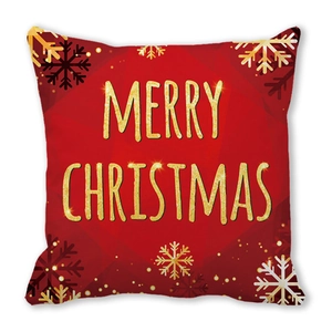 Détail de la housse de coussin rouge de Noël avec texte doré et motifs de flocons de neige