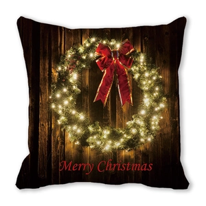 Détail d'une housse de coussin de Noël avec couronne et texte Merry Christmas sur bois