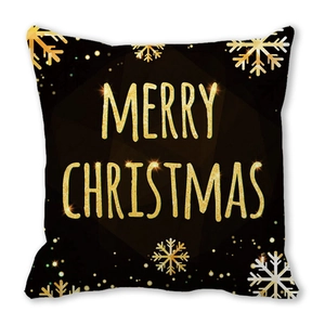 Détail d'une housse de coussin de Noël avec lettrage doré et motifs de flocons de neige