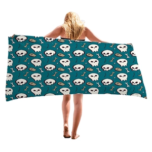 Halloween beach towel with skull and RIP gravestone print on dark teal fabric