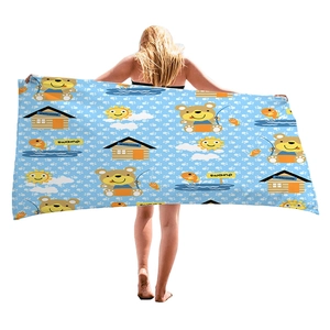 Cartoon bear beach towel with blue polka dots and sun motifs held by a model