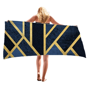 Large geometric beach towel with gold lines on dark blue, full display by model