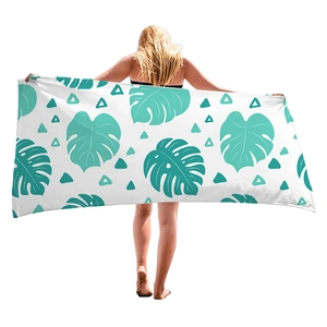 Tropical monstera leaf print beach towel with geometric patterns on model back