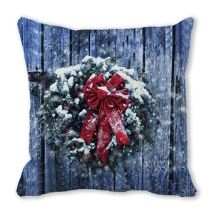 Detail of Christmas wreath pillowcase with red velvet bow on blue wood pattern