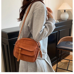 Caramel corduroy rectangular crossbody bag with flap pocket shown in a casual lifestyle setting