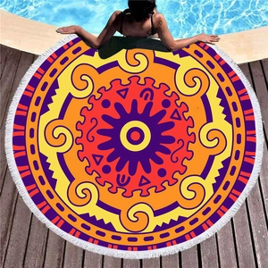 Rundes Mandala-Strandtuch mit weißen Fransen auf einem Holzdeck am Poolrand