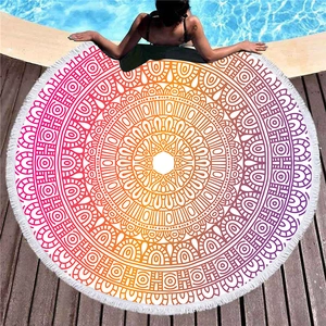 Asciugamano da spiaggia rotondo con mandala colorato e frange su un bordo piscina in legno