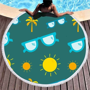 Thick round teal beach towel with sun and palm tree prints and white tassel edges