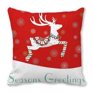 Close-up of linen Christmas pillow cover with reindeer pattern and Seasons Greetings text