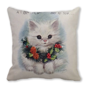 Detail of soft peach skin cushion cover featuring a vintage white Christmas cat print