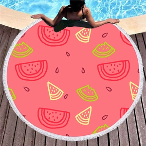 Asciugamano da spiaggia rotondo con anguria e nappe bianche su un ponte di legno in piscina