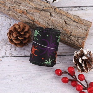 Close-up of Halloween ribbon with colorful spider patterns on black polyester fabric