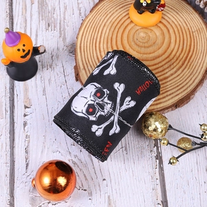 Close-up of Halloween ribbon roll featuring skull prints and red text on black fabric