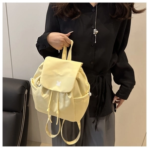 Detail of cream yellow mini drawstring backpack in waterproof nylon material