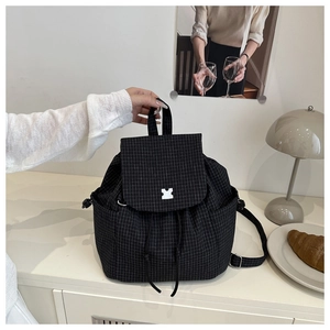 Detail of black mini grid backpack showing drawstring closure and creative puzzle lock