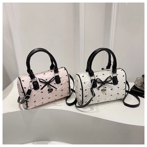 Vue détaillée de mini sacs Boston avec texture florale 3D et motifs de nœuds noirs