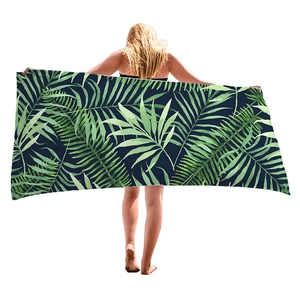 Thick tropical palm leaf print beach towel with deep blue background for vacation