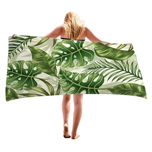 Thick beach towel with vibrant tropical green leaves palm and monstera pattern print