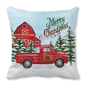 Detail of Christmas pillow cover featuring a red truck, barn, and Merry Christmas text