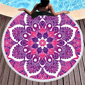 Circular mandala beach towel with white fringes displayed by a swimming pool side
