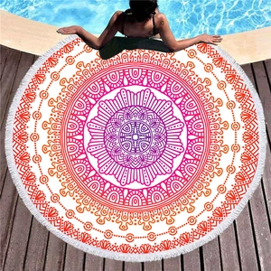 Circular mandala beach towel with red fringe, shown on pool deck for summer vacation